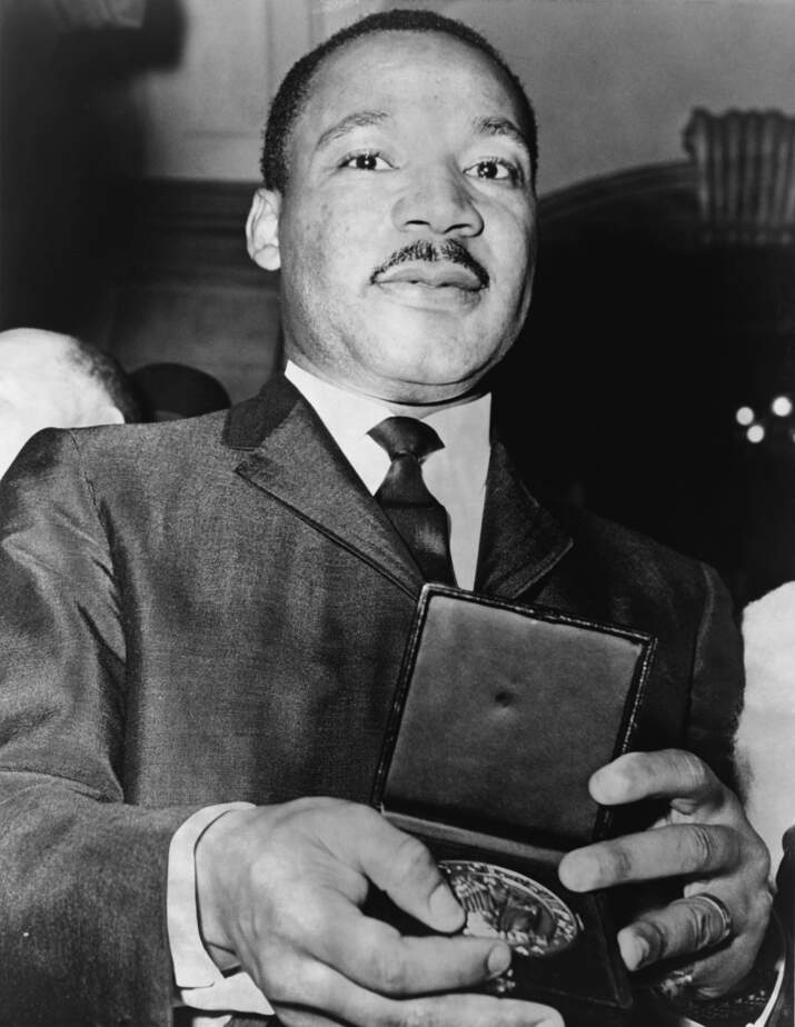 Photo de Martin Luther King qui montre sa médaille, reçue du maire Wagner en 1964